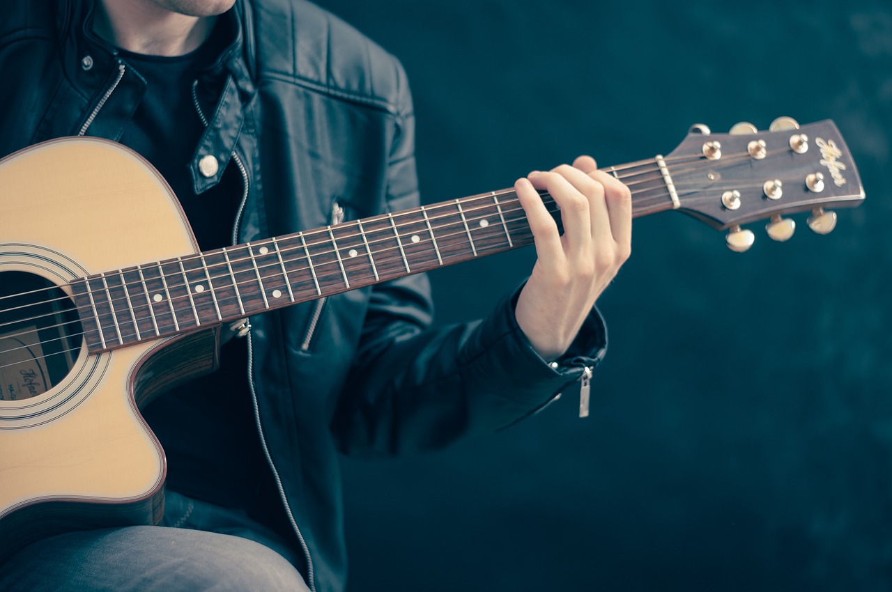 męzczyzna trzymający gitarę