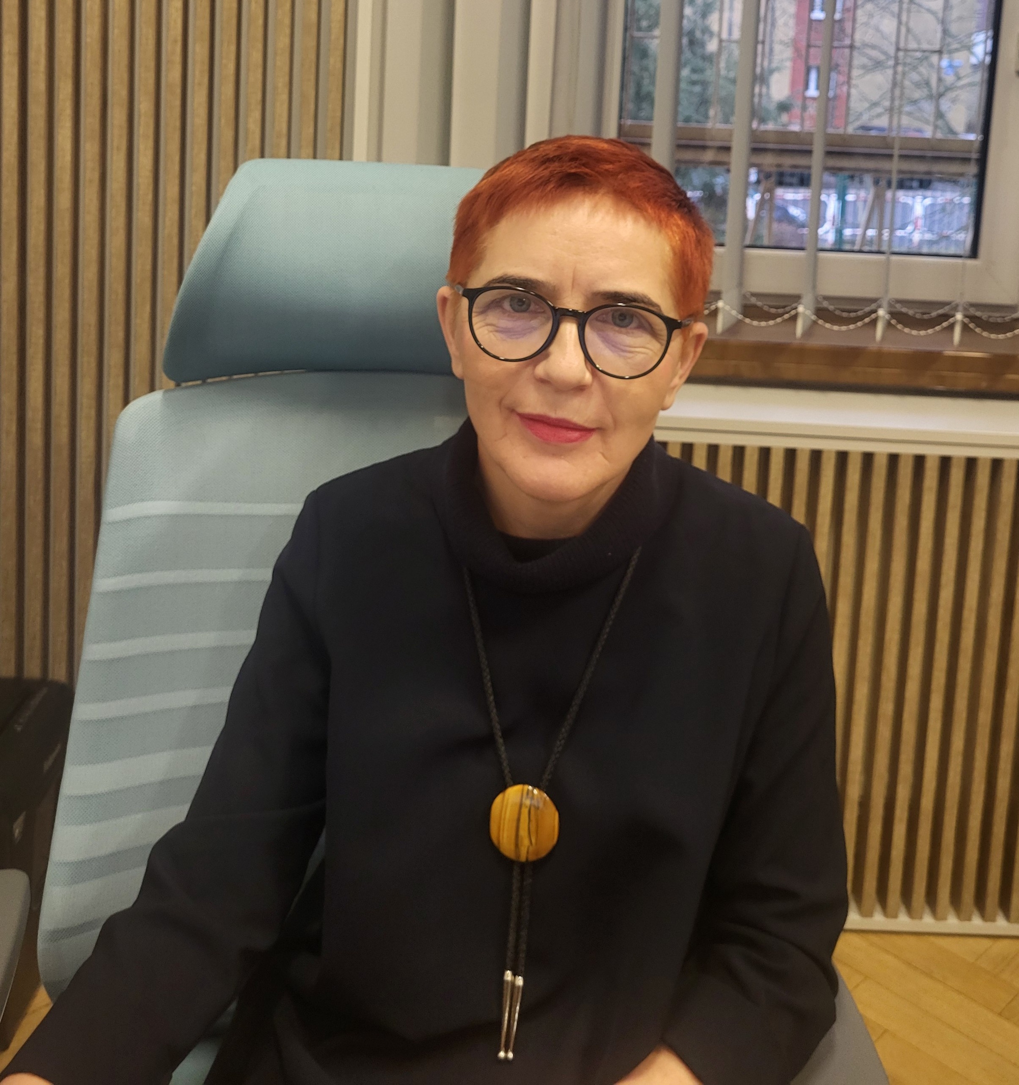 kobieta w okularach siedzi przy biurku