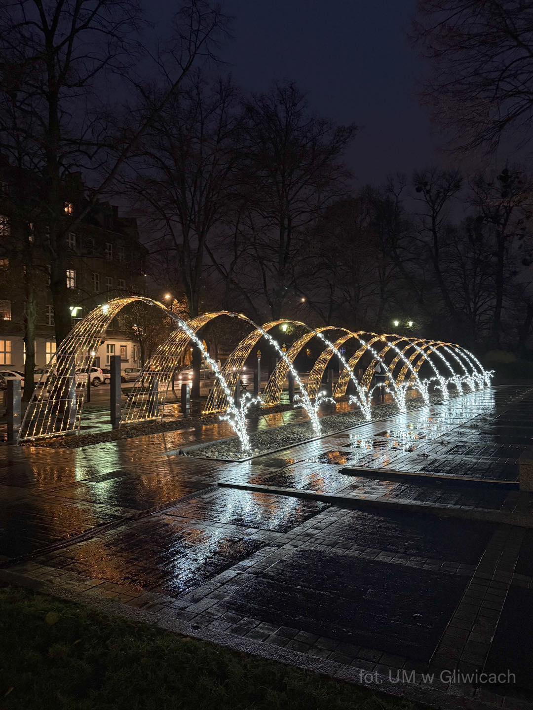 fontanna na placu Piłsudskiego tryskająca wodą, wieczorową porą