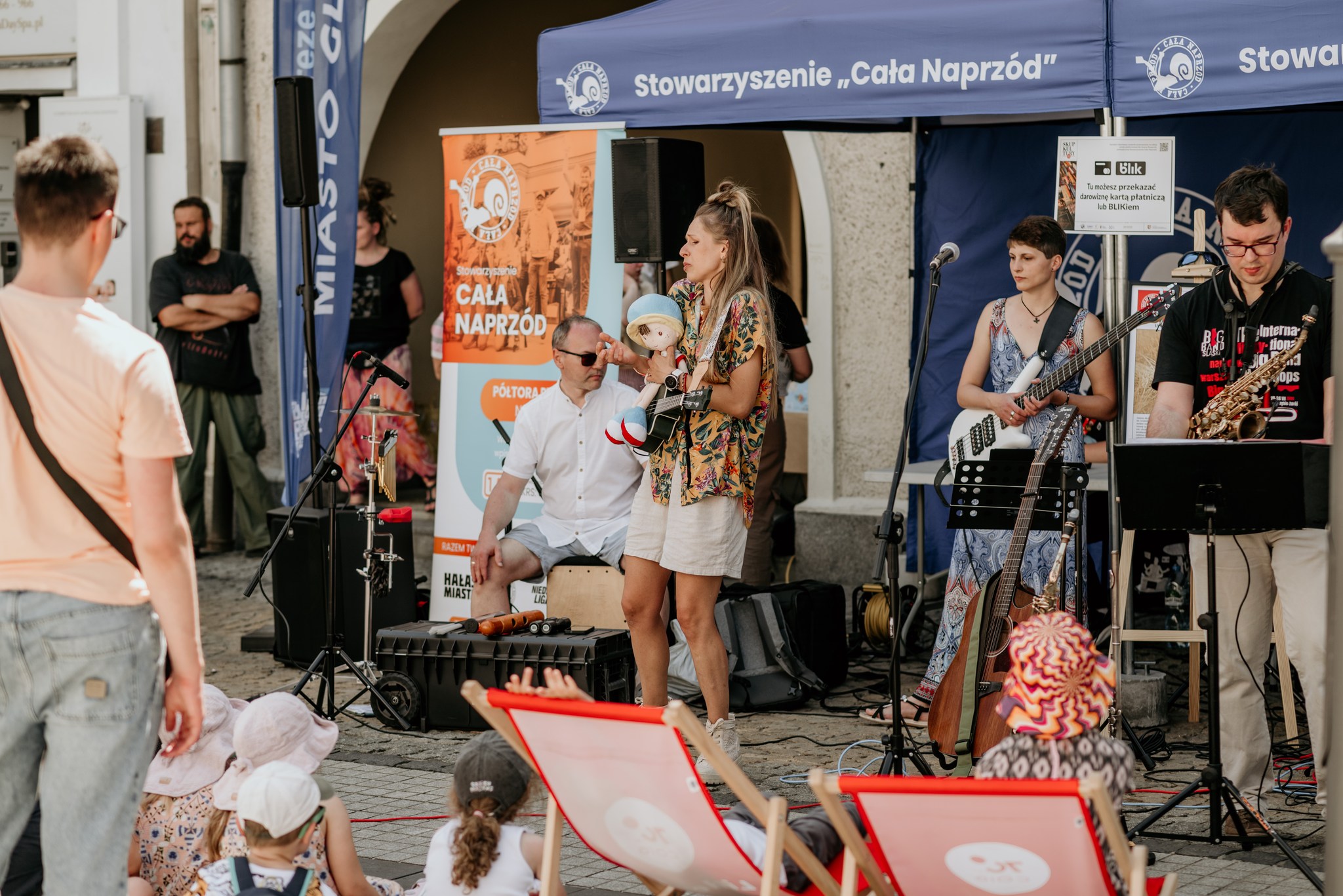 ludzie przy mikrofonach i osoby przyglądające się występom na Rynku