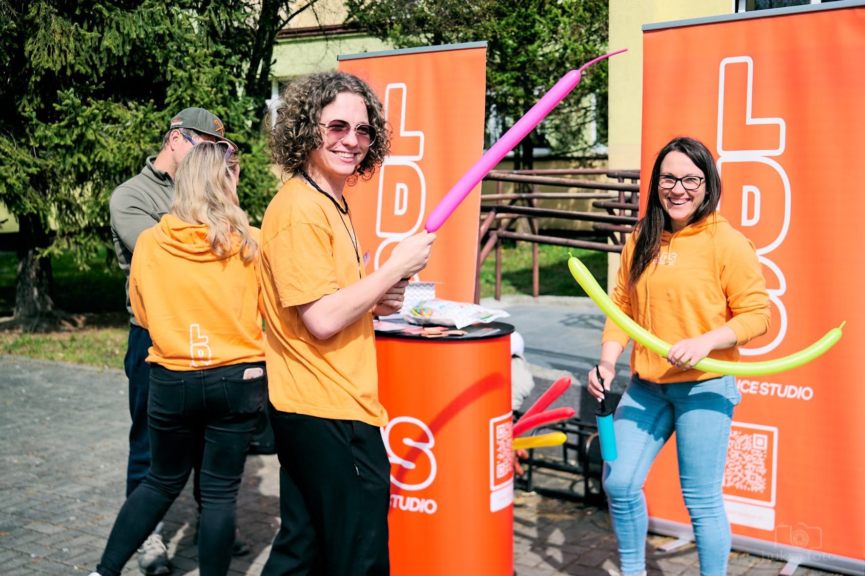 młodzi ludzie w pomarańczowych koszulkach, uśmiechają się