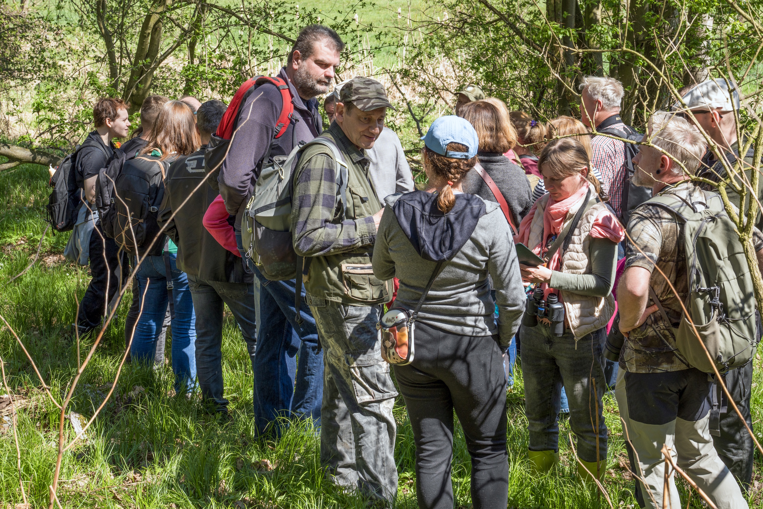 Przyrodnicy opowiadający mieszkańcom o zwiedzanym terenie