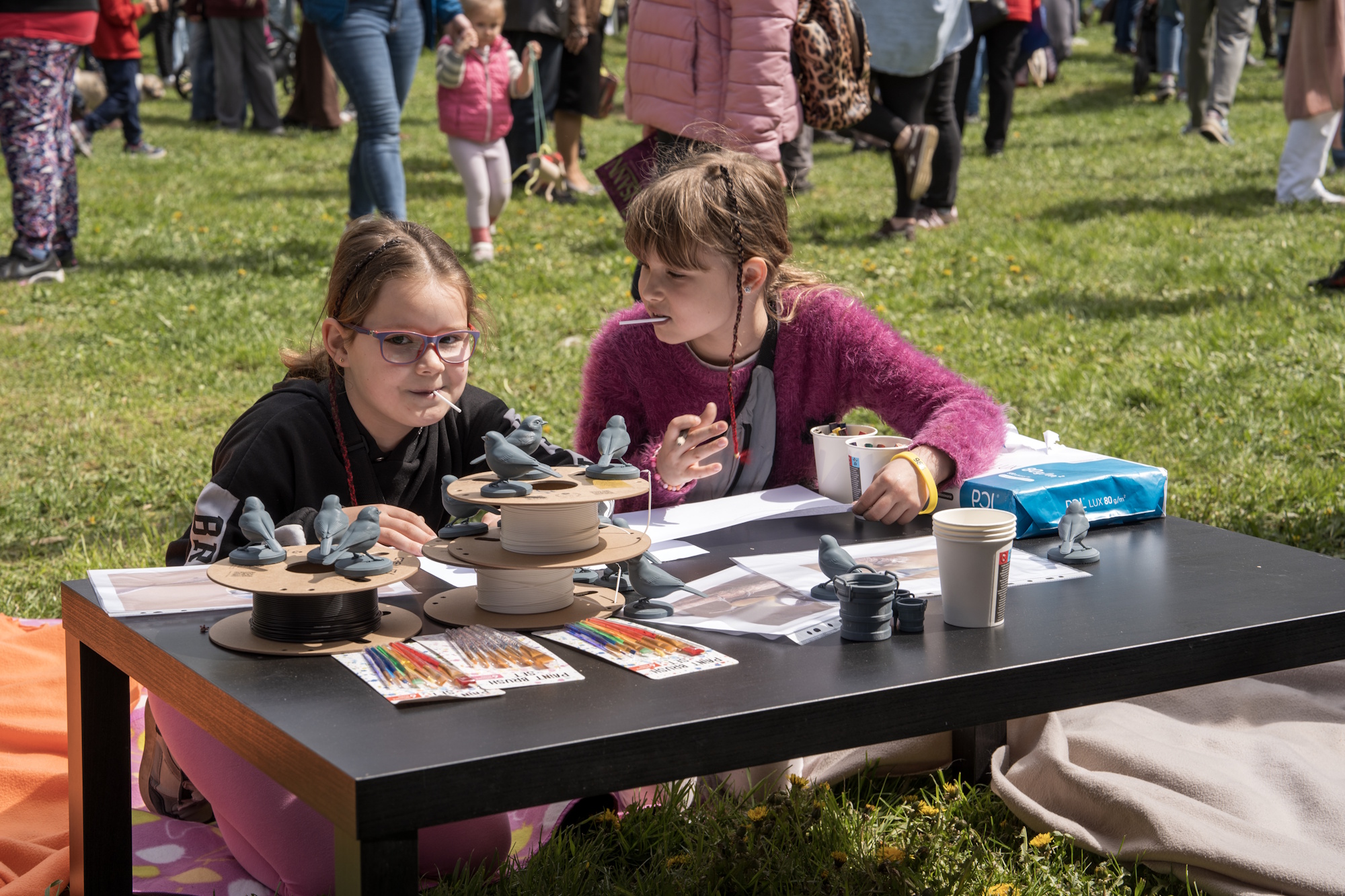 dwie dziewczynki przy stoliku i gliniane ptaszki