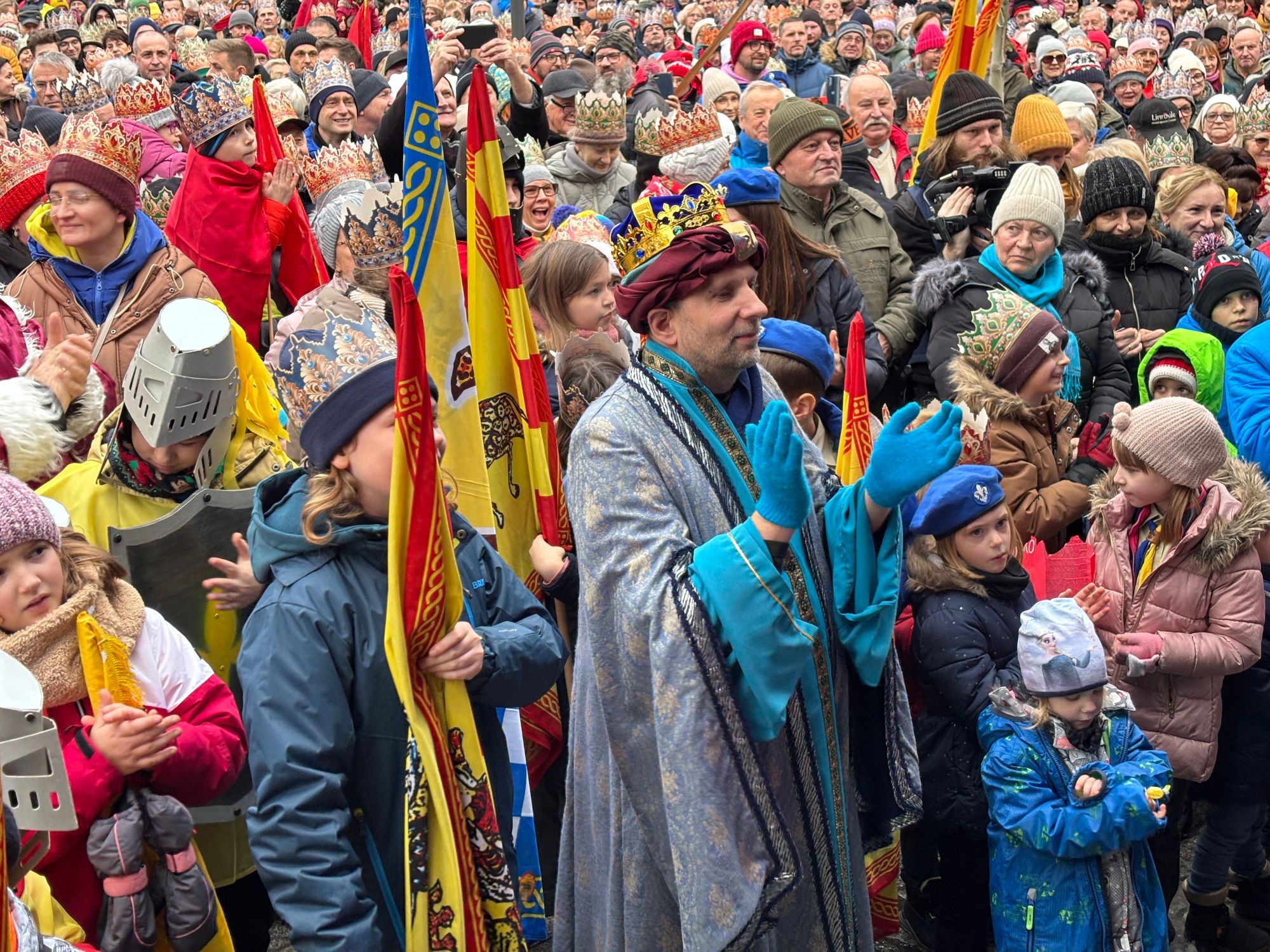 Uczestnik orszaku w przebraniu króla na Rynku z innymi ludźmi