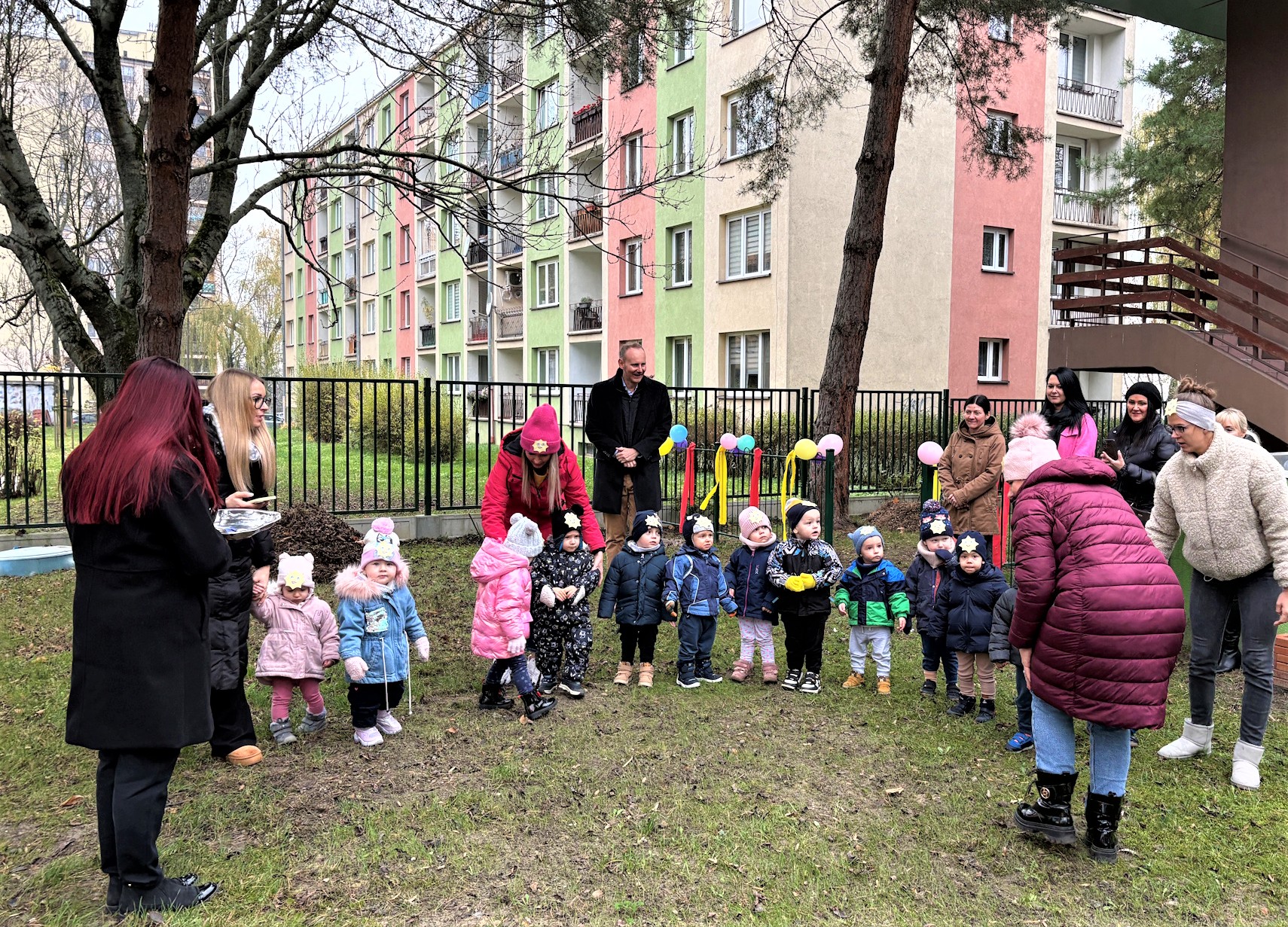 dzieci, opiekunki i zastępca prezydent Gliwic podczas przecięcia wstęgi na placu zabaw