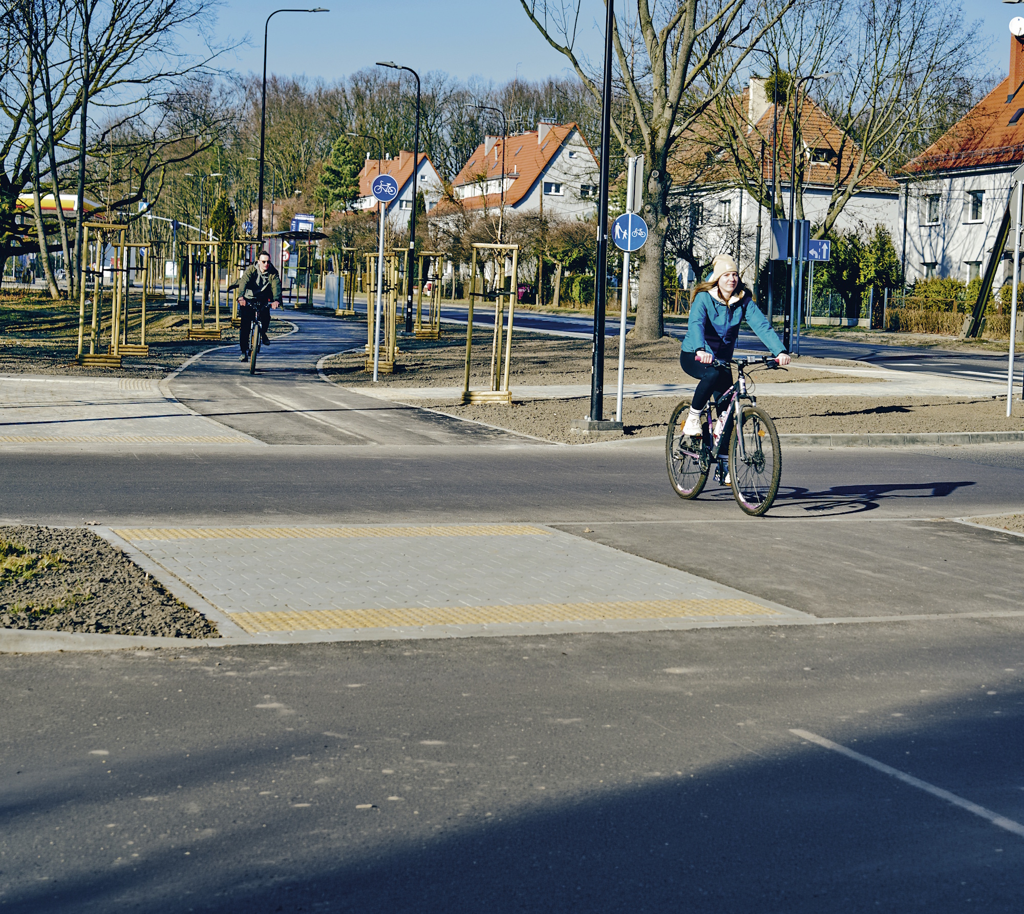 rowerzystka przejeżdża jezdnię w śladzie ścieżki rowerowej