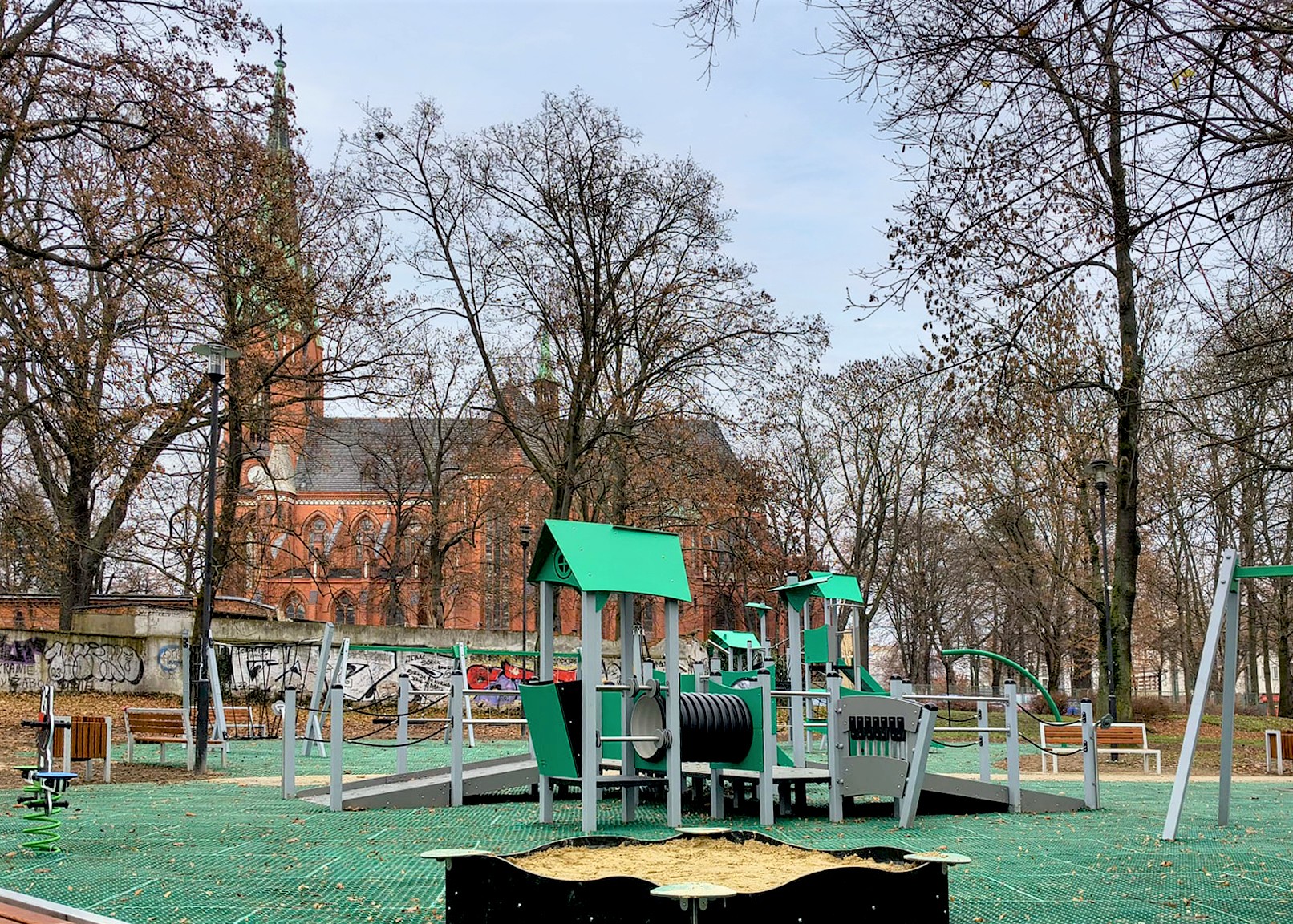 plac zabaw z piaskownicą i urządzeniami do zabawy