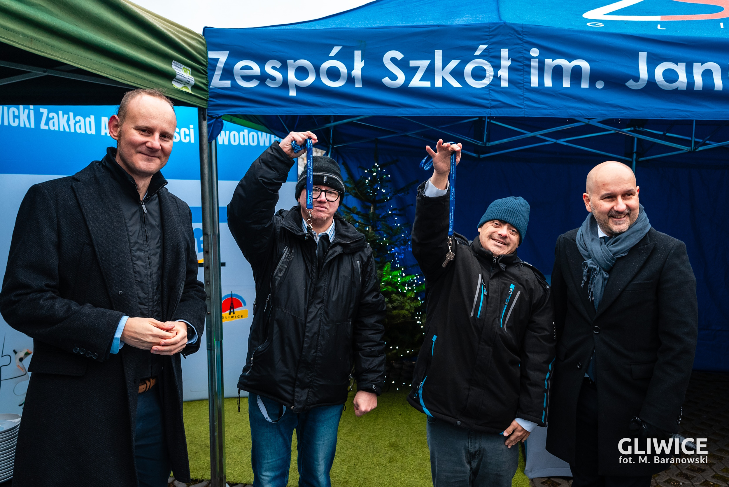 Nowi lokatorzy trzymający klucze i pozujący z prezydentem Gorczyńskim oraz dyrektorem Ocieczkiem