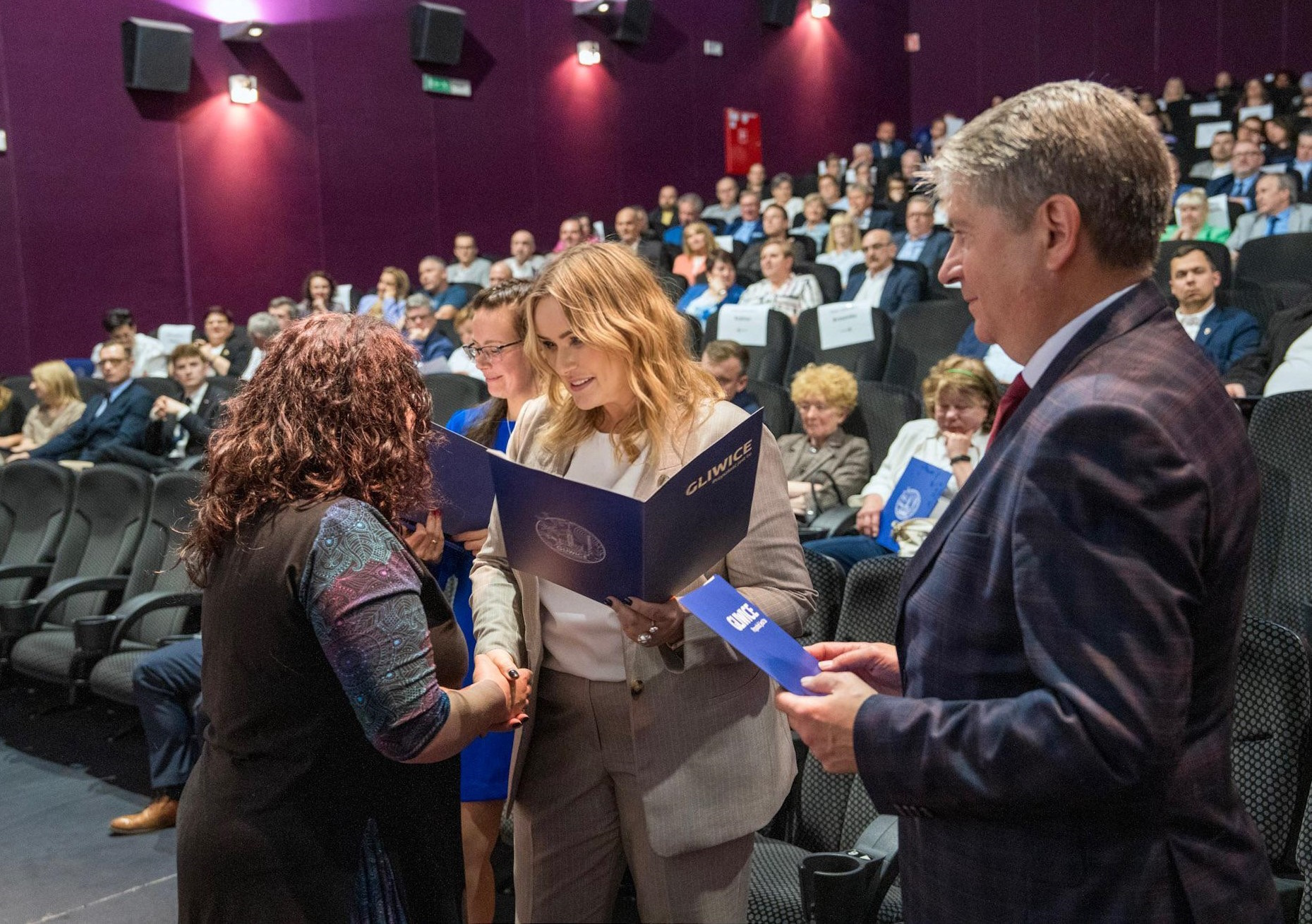 Prezydent i przewodniczący rady miasta wręczają zaświadczenie radnemu