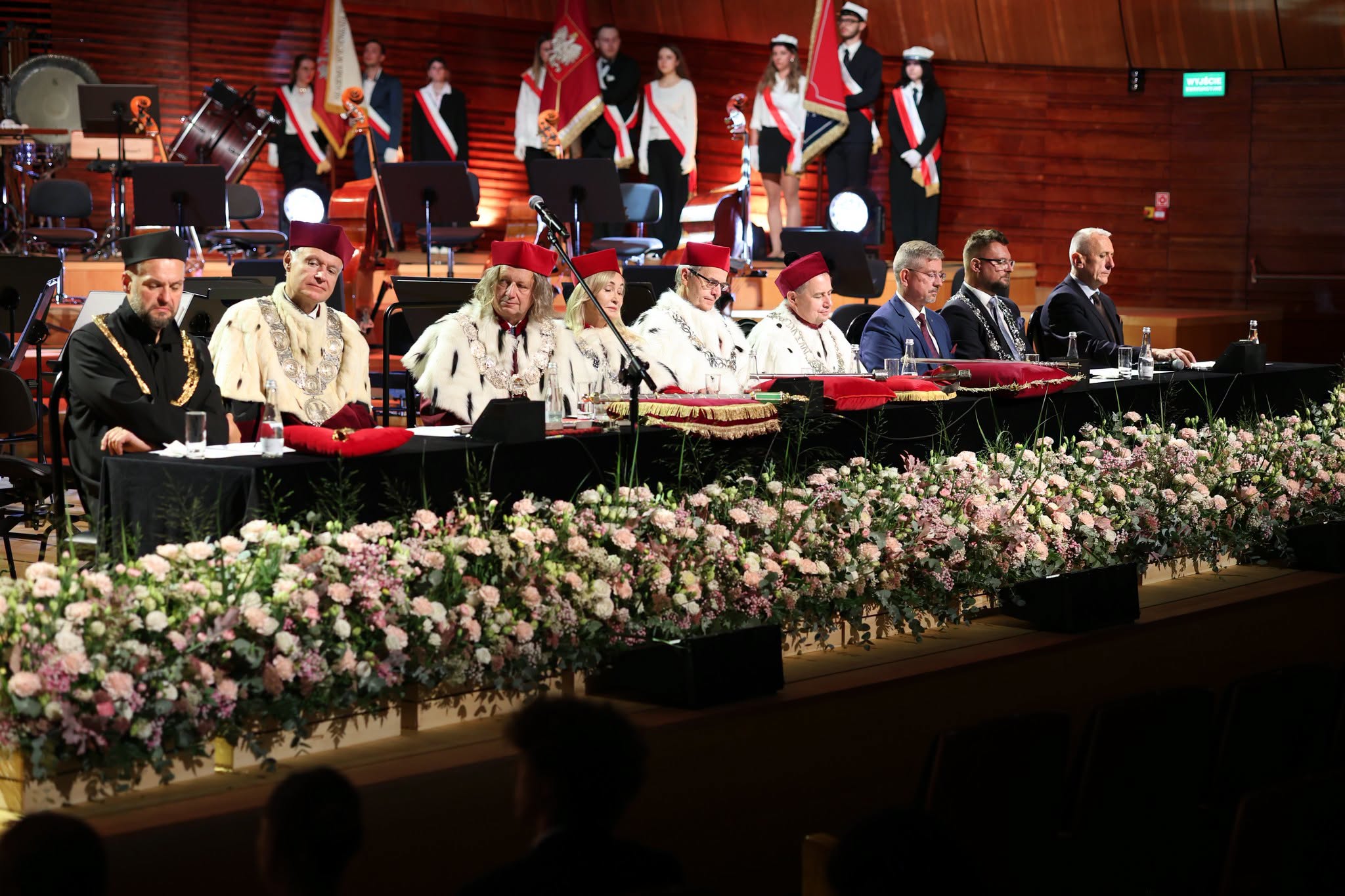 ludzie w płaszczach z gronostajami siedzą za stołem