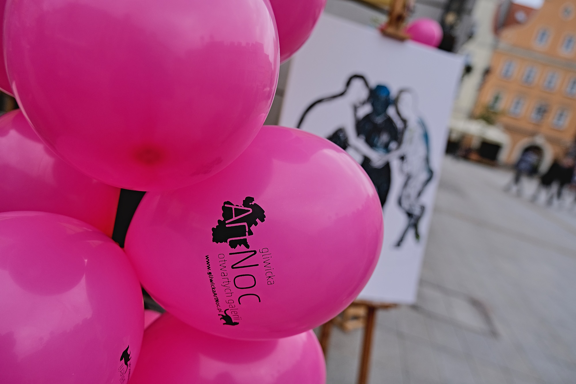 Różowe balony, w tle sztaluga i Rynek