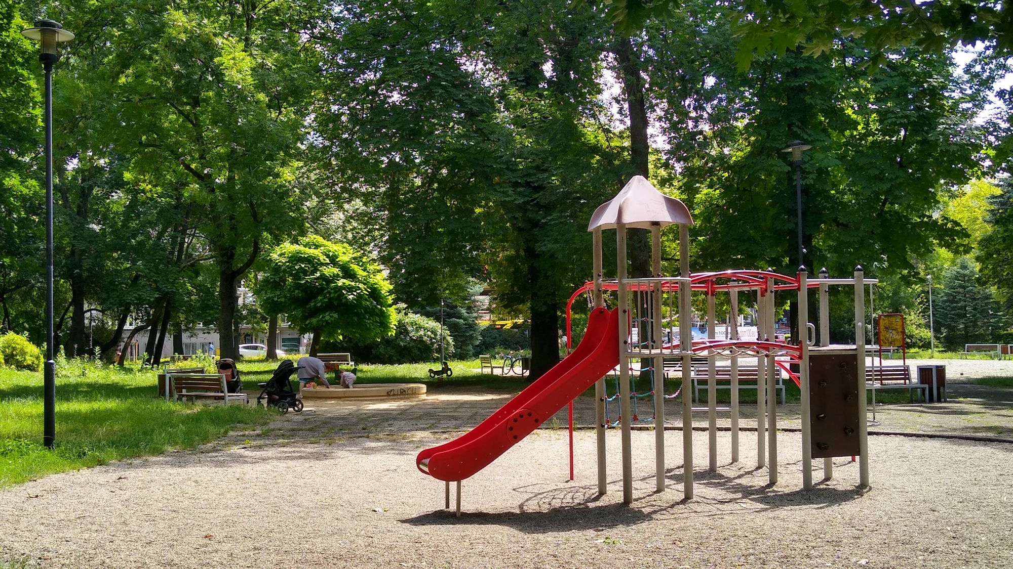 zjeżdżalnia, w tle kobieta z dzieckiem