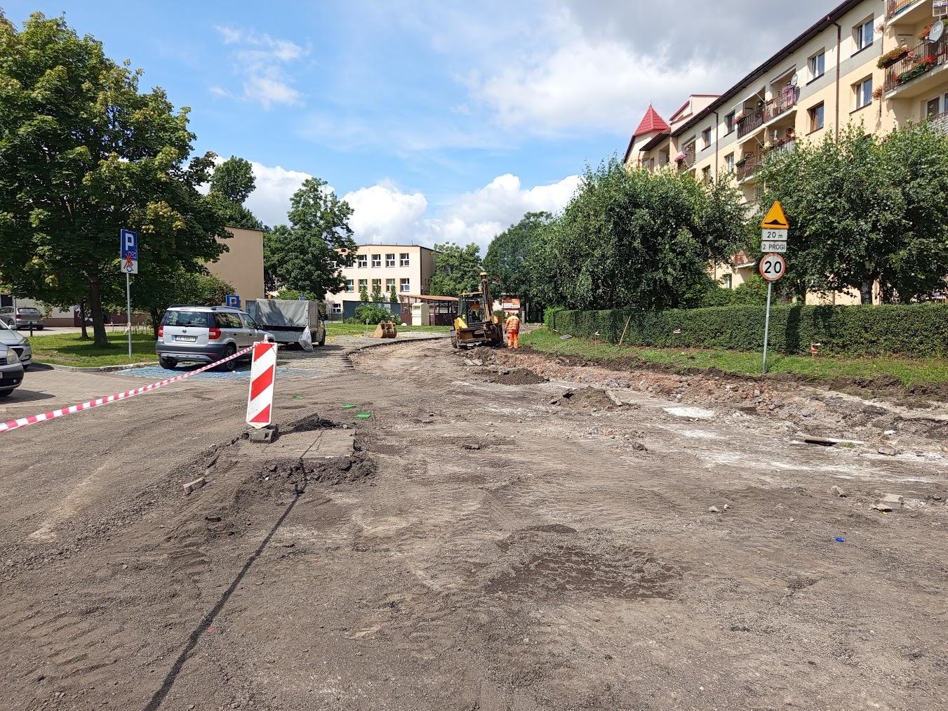 piasek, wykopy, asfalt, budynki