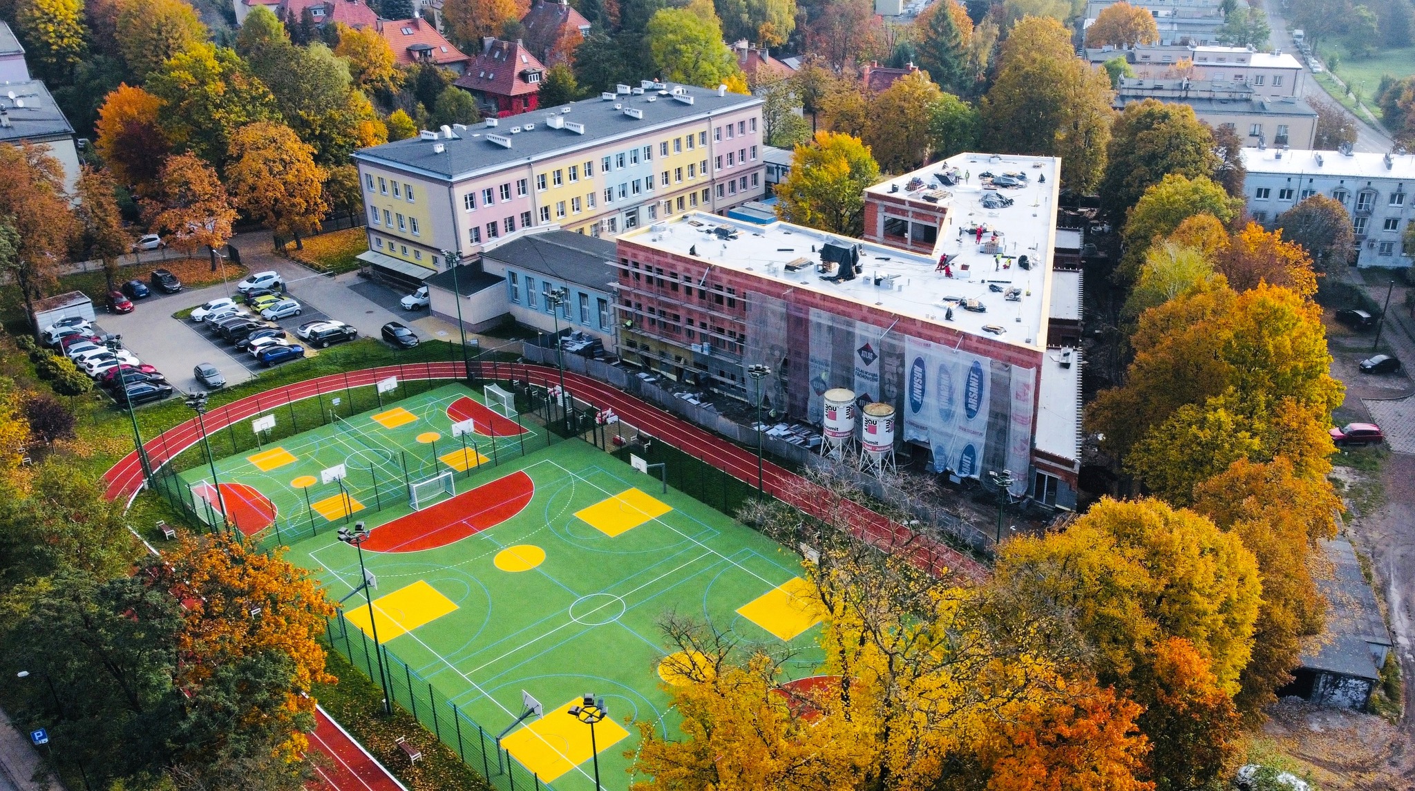 budynki, boisko, drzewa