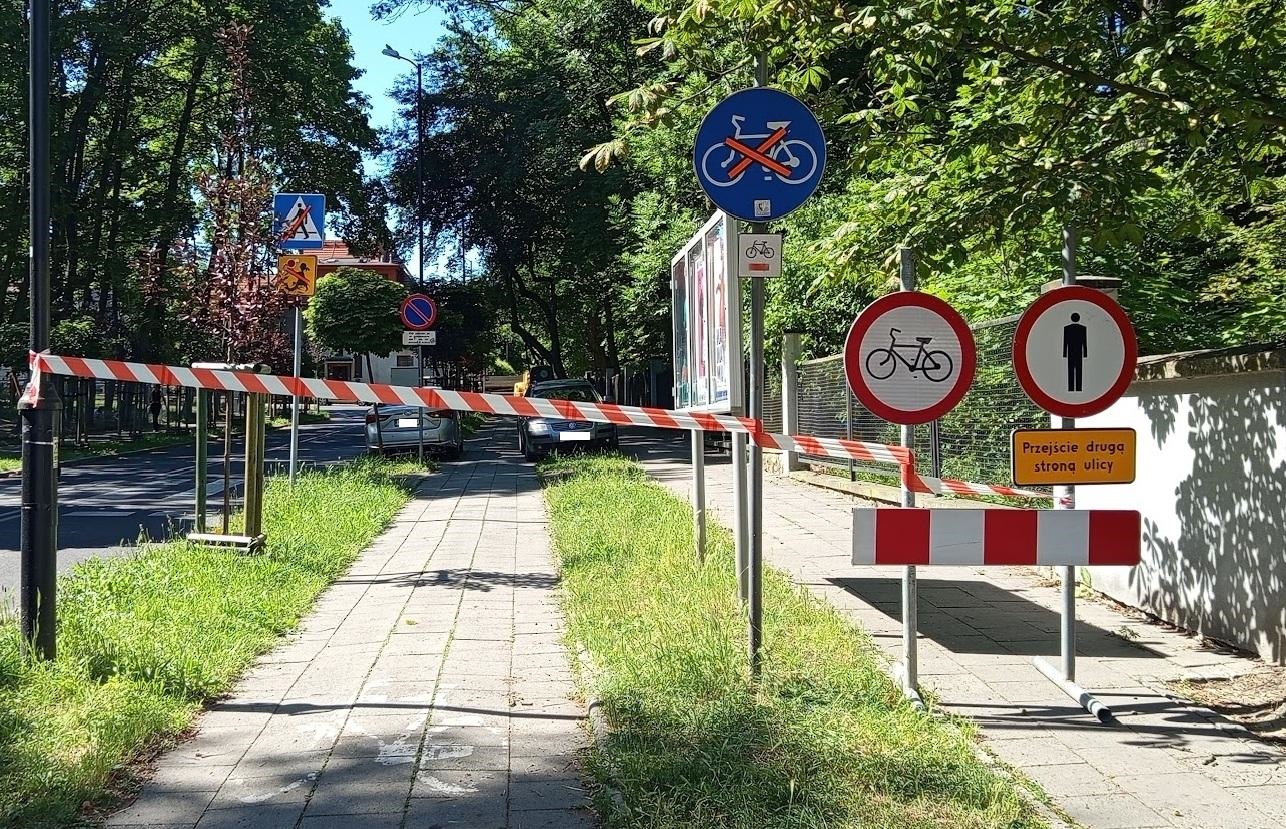 taśma odgradzająca plac budowy alei Sikornik i koparka