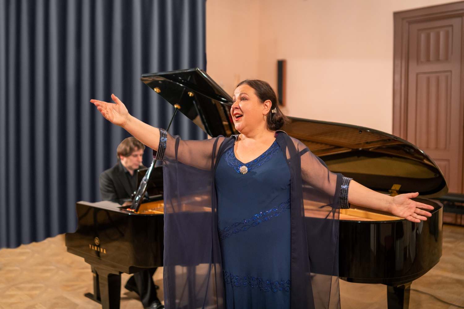 Kobieta, za nią mężczyzna przy fortepianie