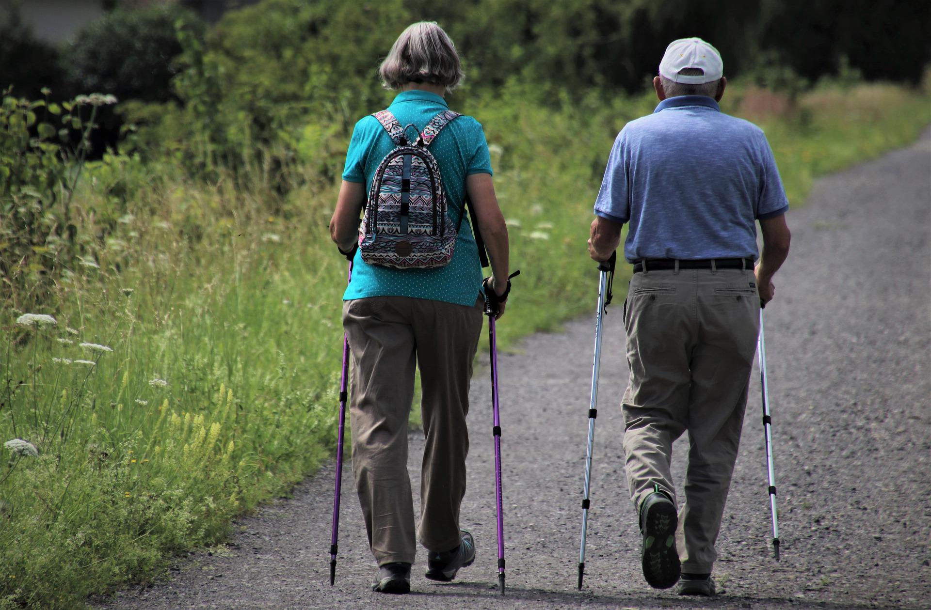 dwójka seniorów spaceruje z kijkami nordic walking