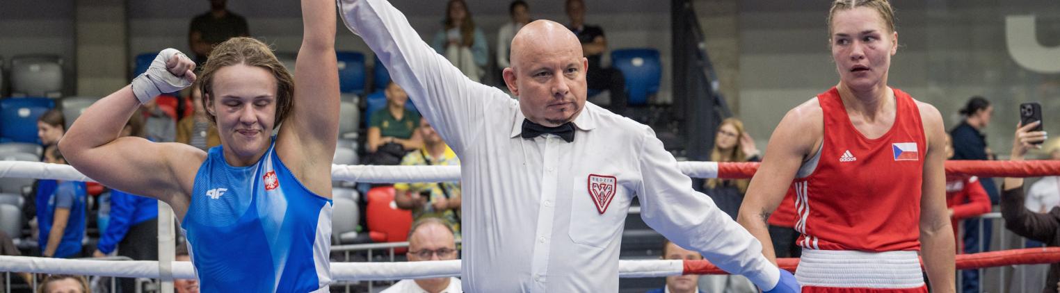 Sędzia unoszący rękę wygranej pięściarki