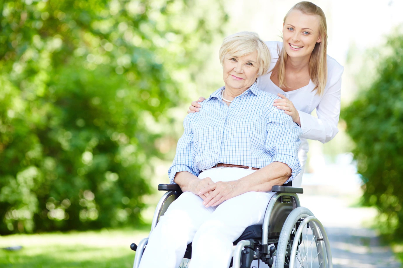 zdjęcie ilustracyjne - osoba na wózku inwalidzkim wraz z opiekunem