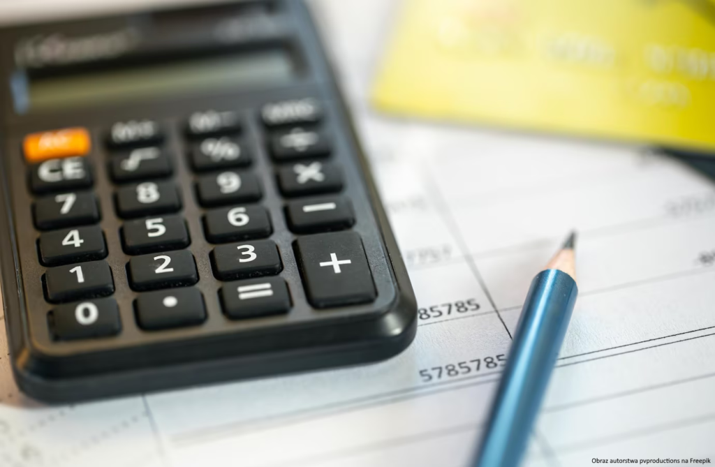 Obrazek ilustrujący rozliczenie podatku - kalkulator, ołówek i formularz podatkowy na stole