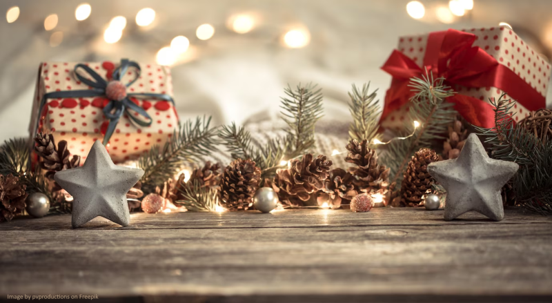 Dekoracja świąteczna zrobiona z szyszek, gałązek choinkowych, gwiazdek i prezentów. Wszystko to oświetlone drobnymi lampkami.