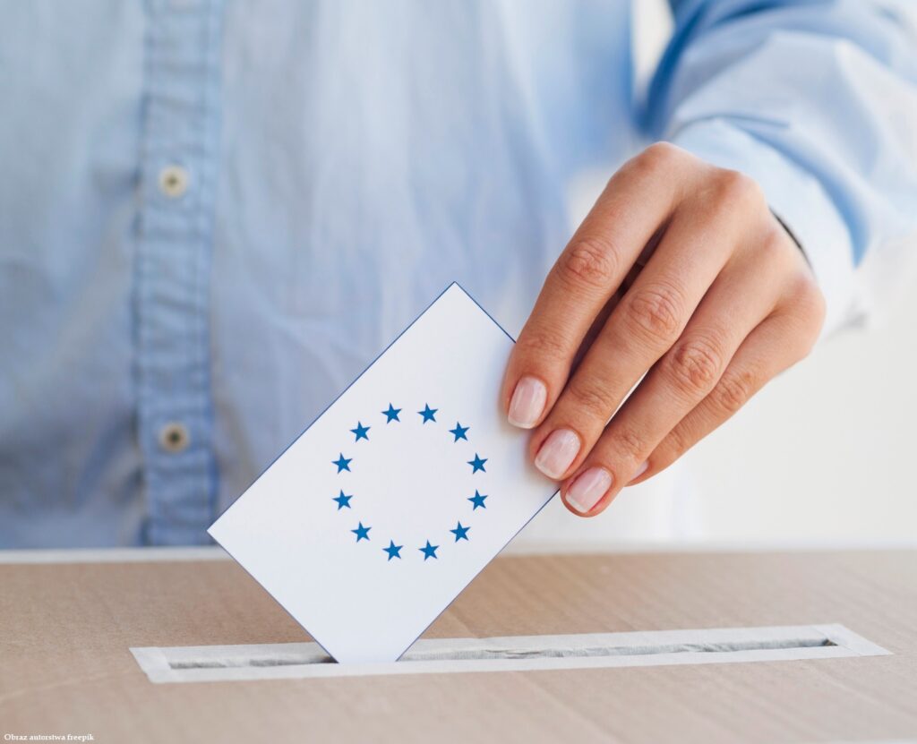 Kobieta umieszcza kartę europejskiego głosowanie w pudełku